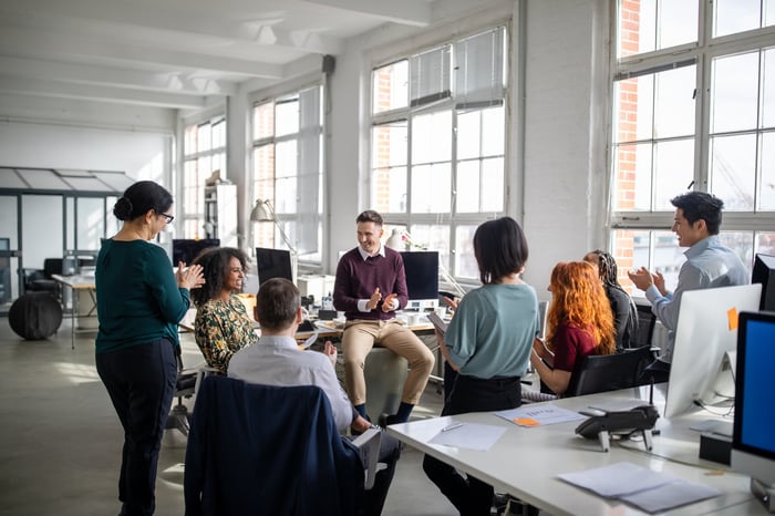 A group of people sitting and talking together in an office.