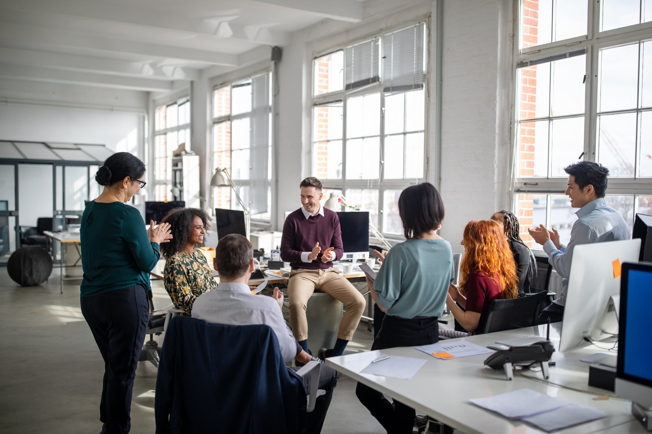 A group of people sitting and talking together in an office