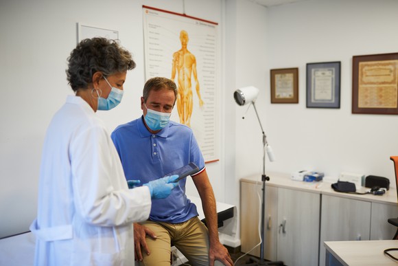 A doctor speaks with a patient during an appointment.
