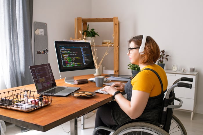 A computer programmer works on two computers at home.
