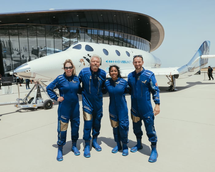 Branson poses with other crewmembers in front of the Unity spacecraft.