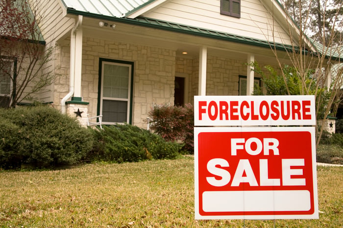 house with foreclosure sale sign
