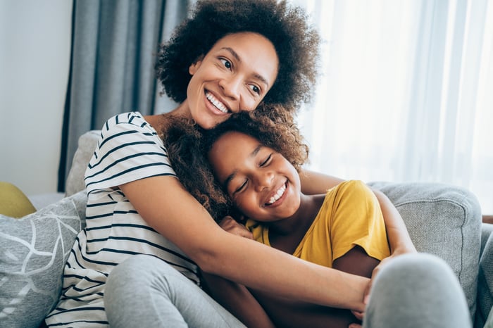 Adult and child sitting together on a couch. 