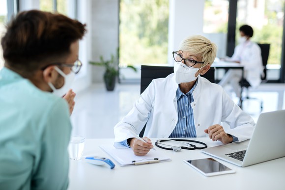 A doctor and patient speak with each other at an appointment.