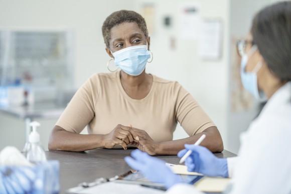 A doctor speaks with her patient during an appointment.
