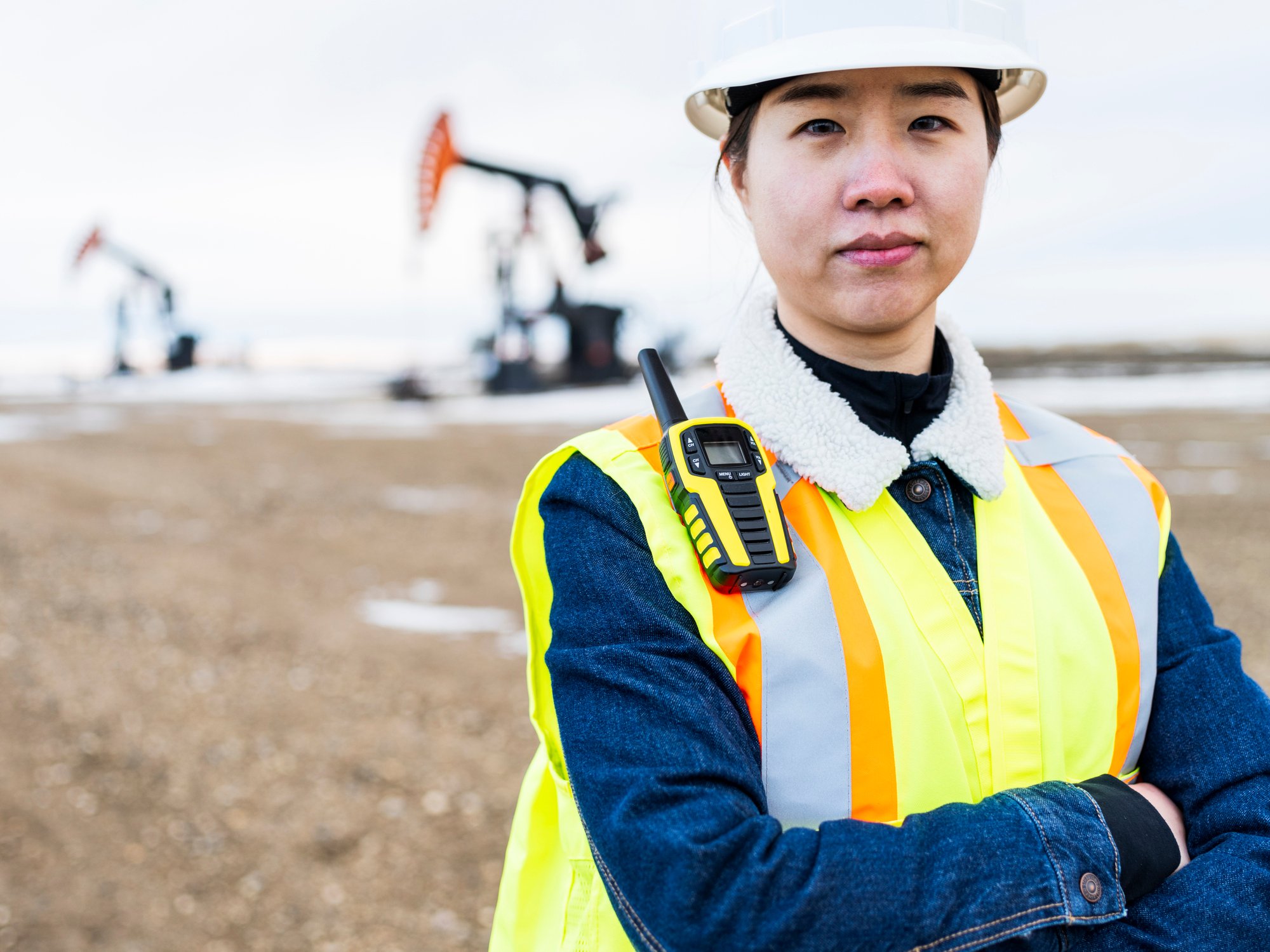 21_05_18 A person in protective gear with oil wells in the background _GettyImages-1210681471