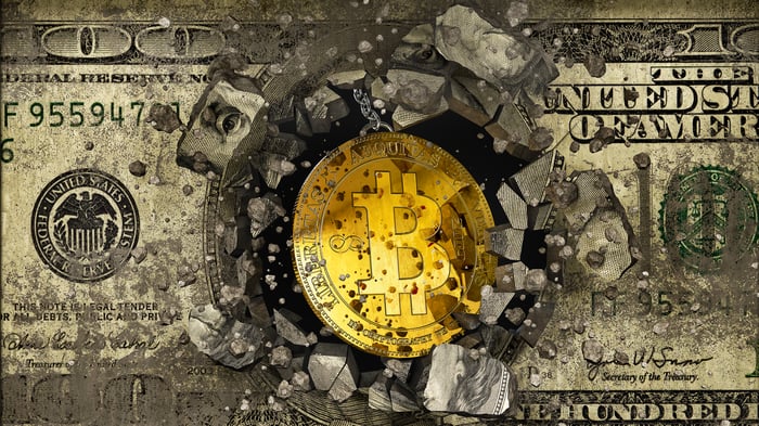 A Bitcoin logo breaking through a hundred-dollar bill.