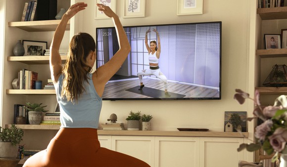 A person working out in their home using the Peloton App.