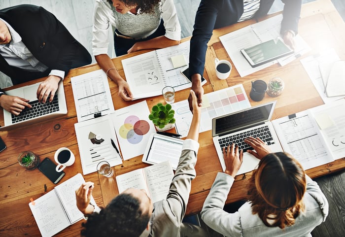 High angle shot of businesspeople shaking hands during a meeting in an office.