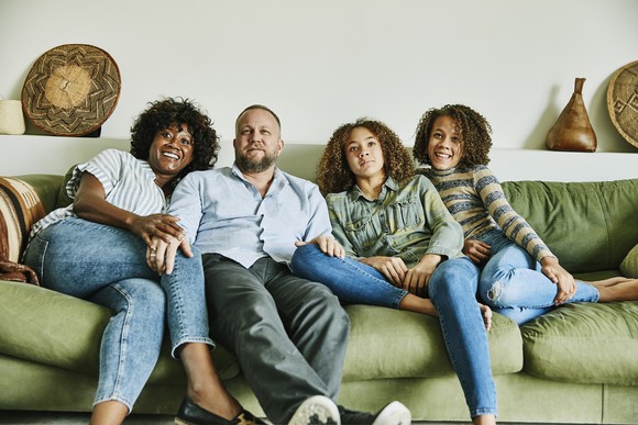 A family sitting on a couch.