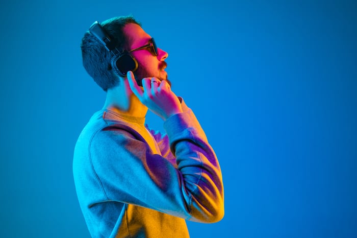 Person listening to music on headphones.