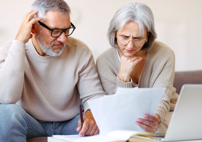 Two people with serious expressions looking at documents.