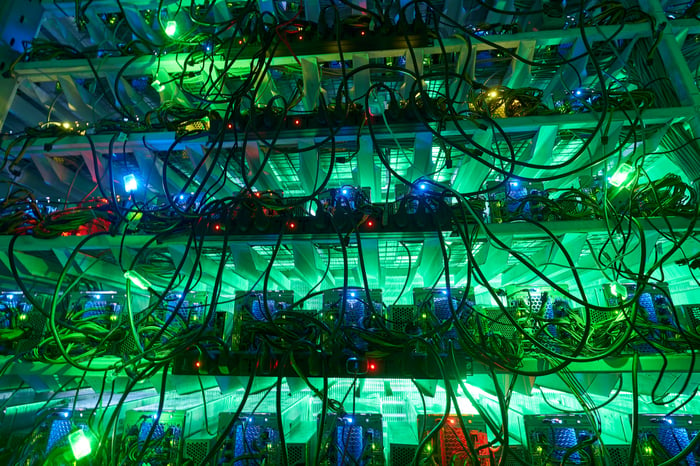 An ASIC cryptocurrency mining farm lit by dim background lights. 