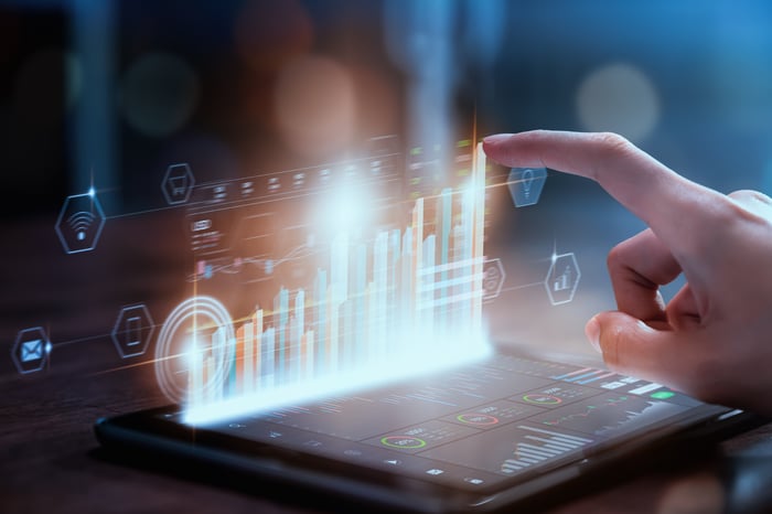 A businessperson touches a financial chart on a tablet.