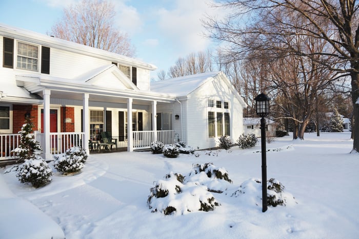 House with snow-covered lawn.