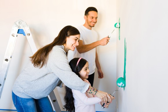 A family painting a wall.