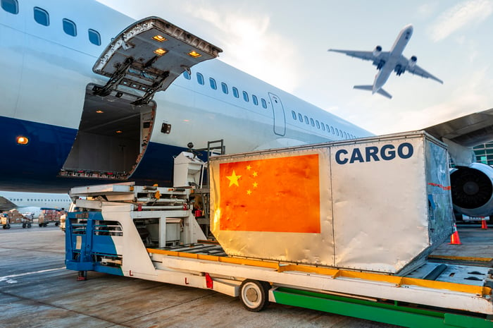 A flag of China affixed to a container being loaded onto a cargo plane.