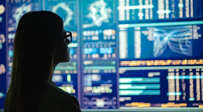 A person looking at a wall display filled with digital data.