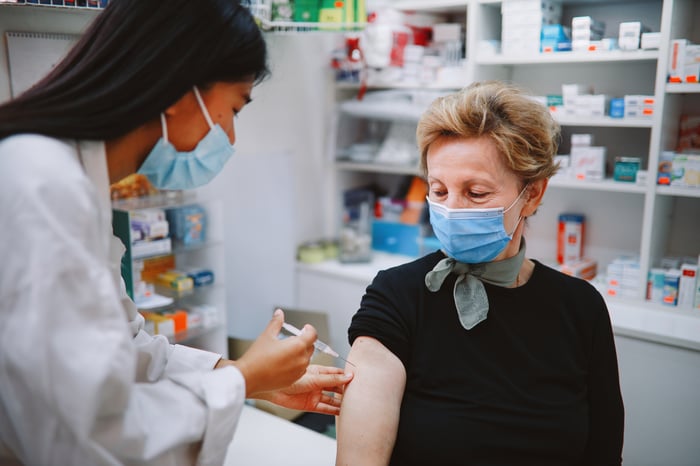 Pharmacy worker giving someone a shot.