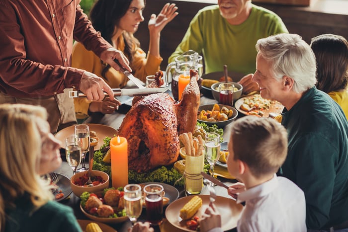 People at table with turkey in center