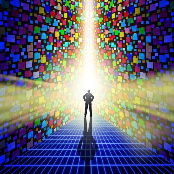A man stares at a beam of light emitting through mosaic digital walls.