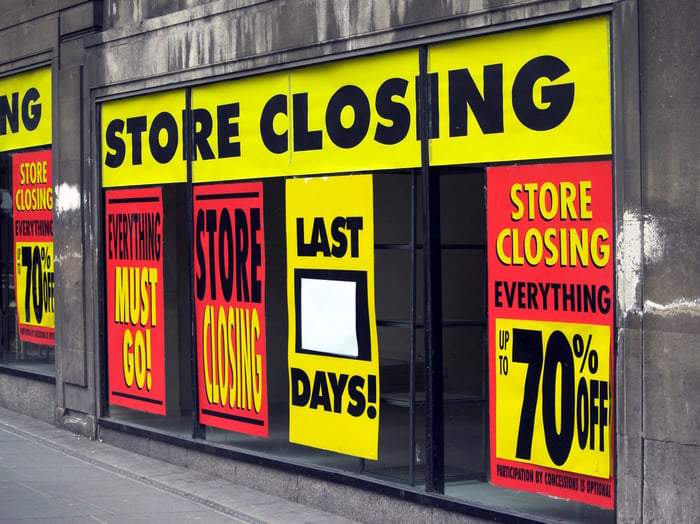 Empty storefront with store closing signs.