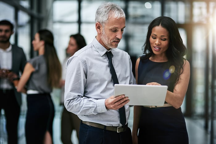 Businesspeople looking at a tablet.