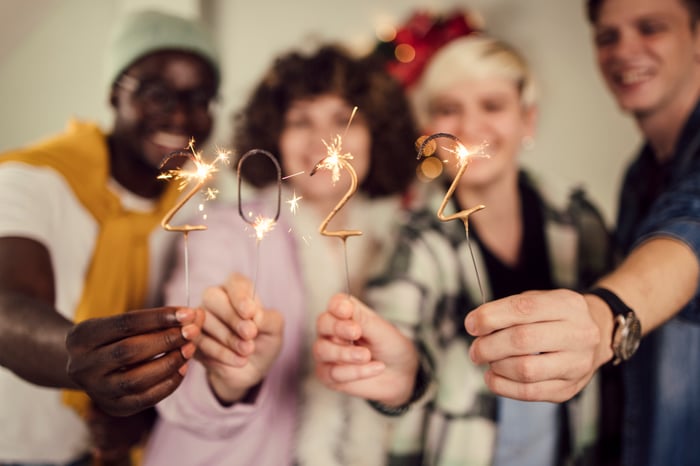 A group of people holding sparklers spelling out 2022.