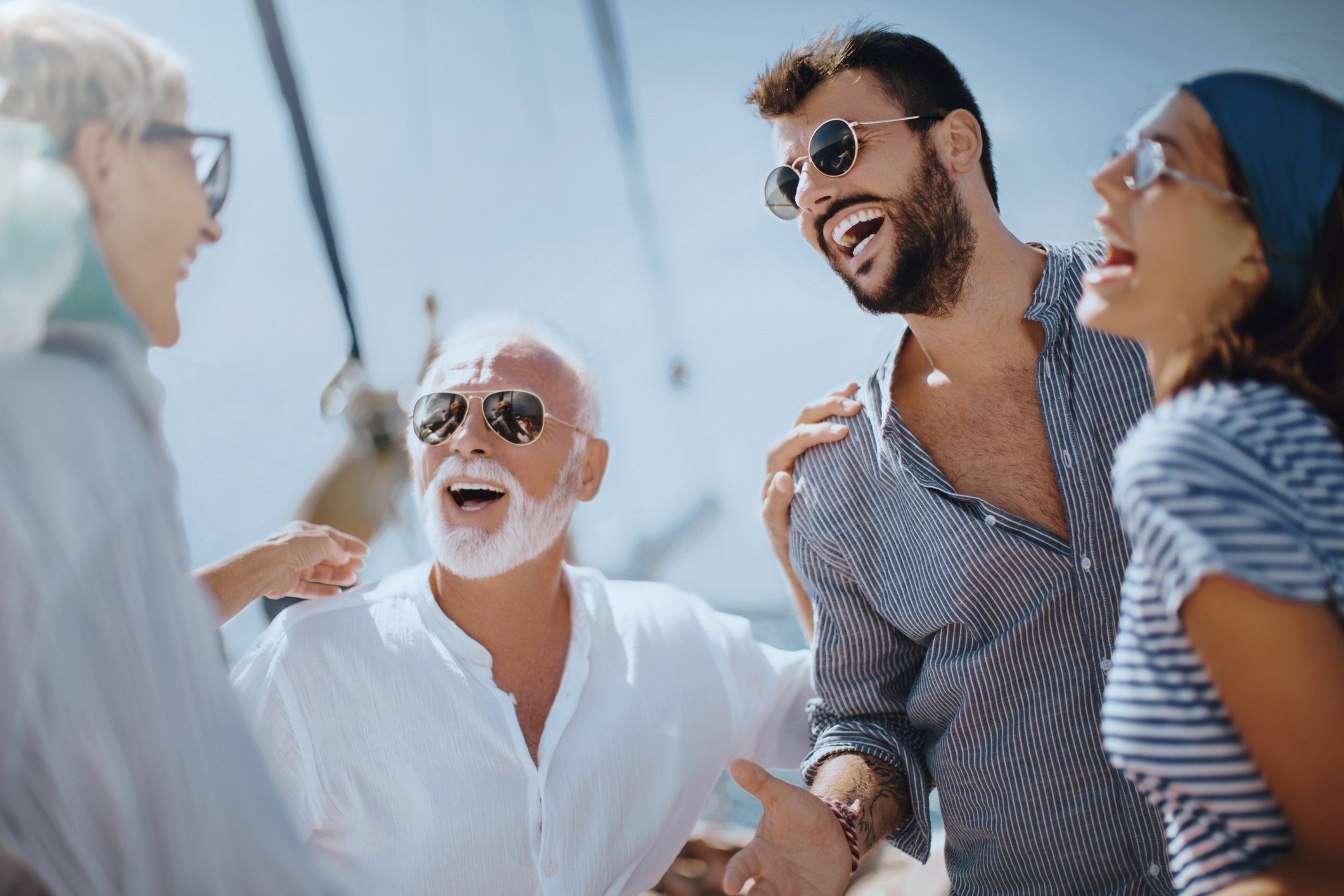 Four people facing each other smiling and laughing