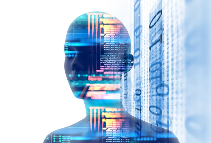 A digital face appearing amongst computer code and a digital background.