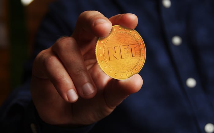 Hand holding an NFT coin.