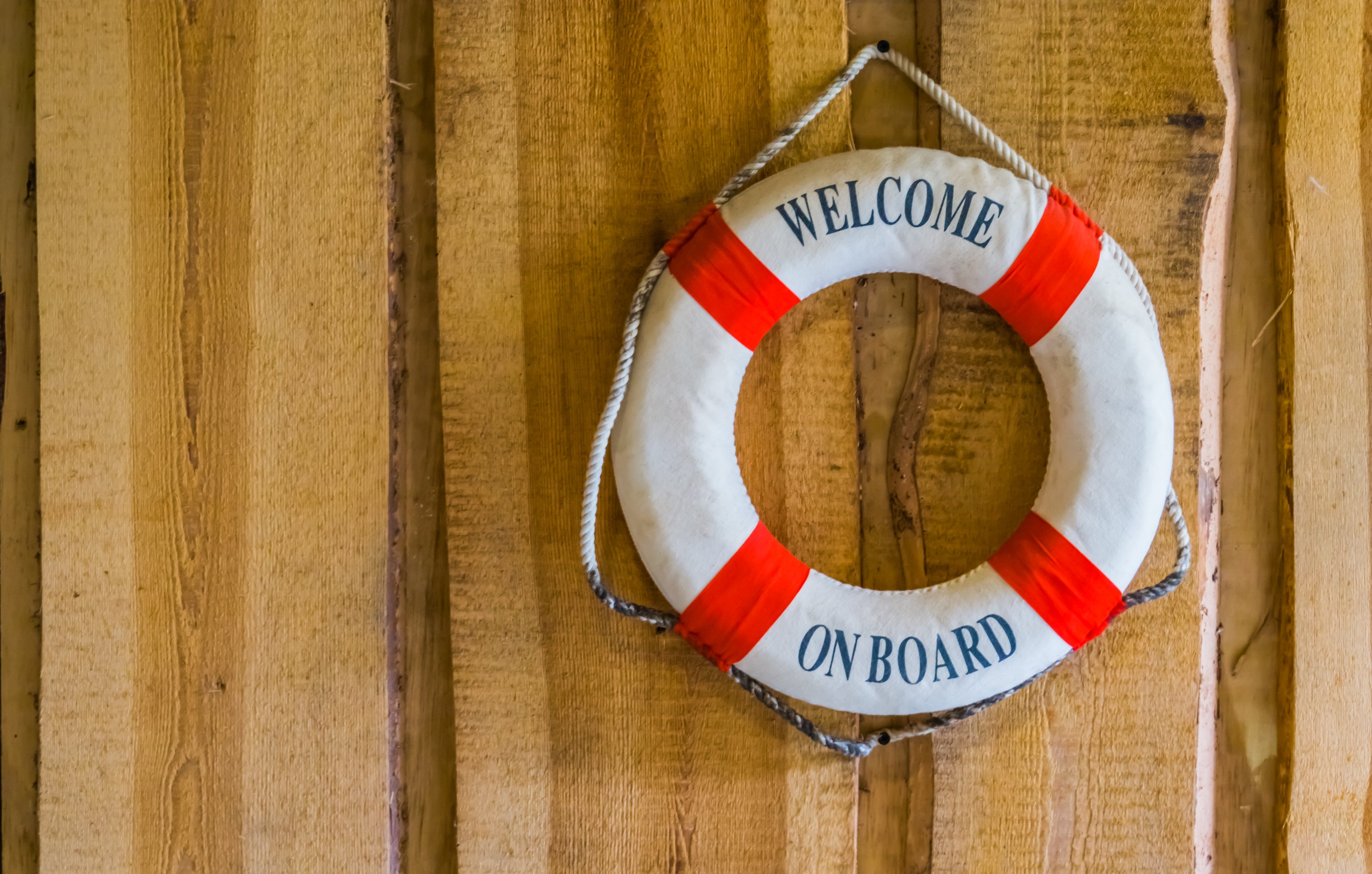 Life preserver reading WELCOME ON BOARD hangs on a wall