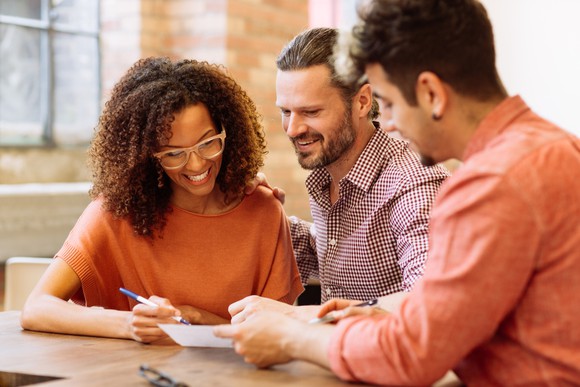 Smiling couple working with a financial consultant.
