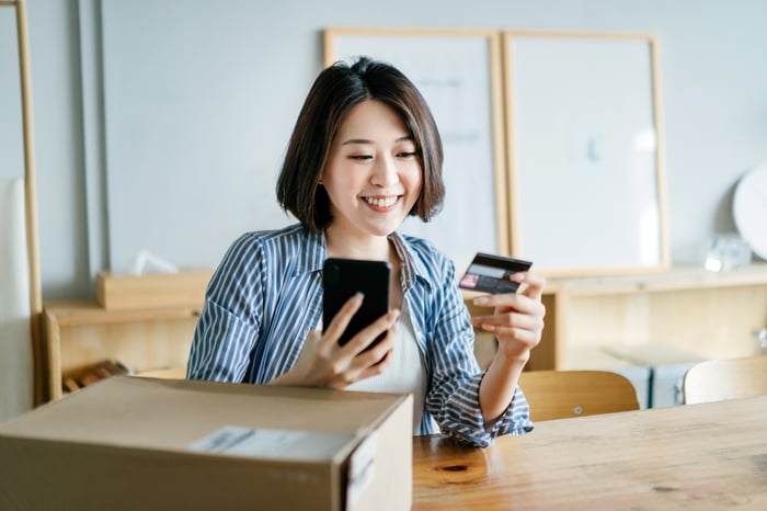 A shopper uses a credit card on a smartphone app.