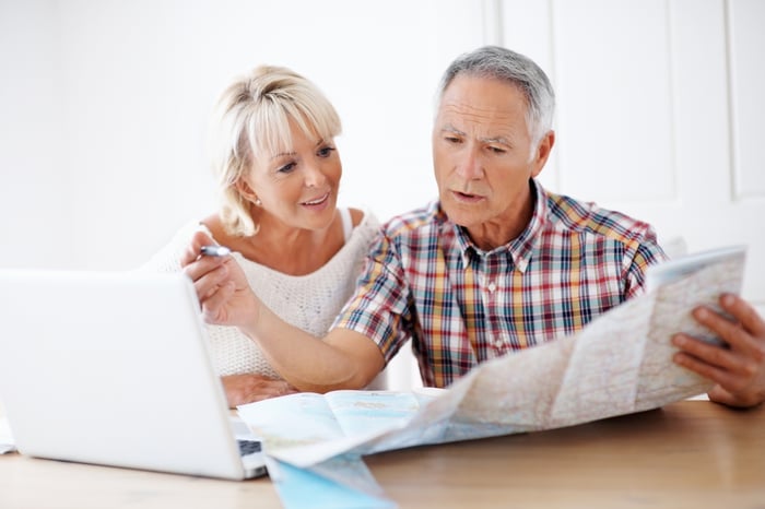 Two people at a laptop looking at a map.