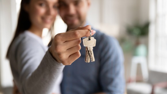 Couple holding keys to their new home.