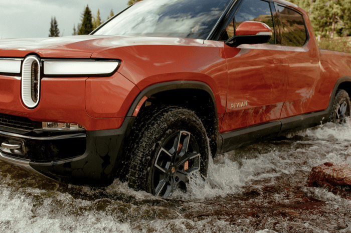 La camionnette R1T de Rivian traverse un ruisseau.  