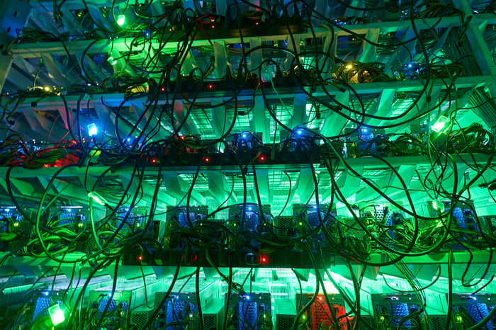 A multi-level crypto mining farm backlit by florescent lights. 