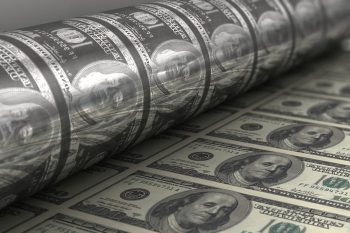 A printing press producing crisp one hundred dollar bills. 