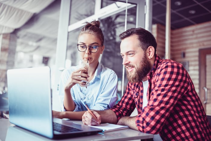 Two people looking at a laptop screen.