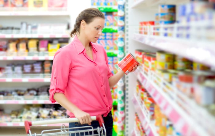 A person in a store holding a can.