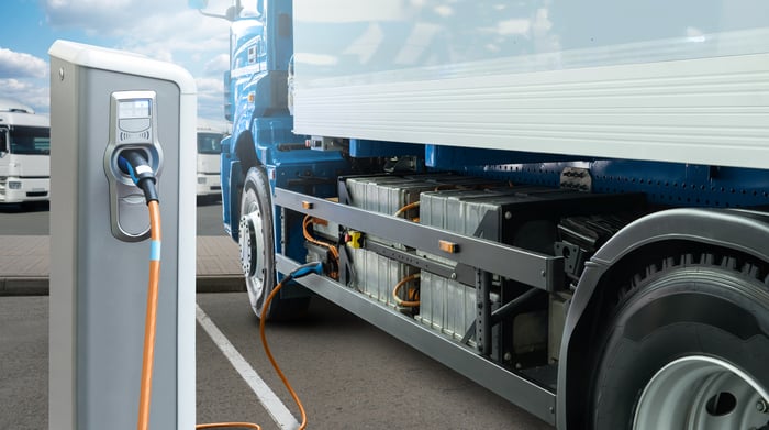 An electric truck getting charged at a charging station.