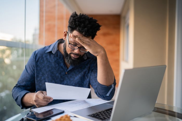 A person at a laptop looking at a document.