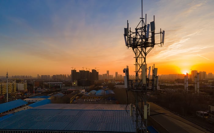 Wireless towers in a city at sunset.