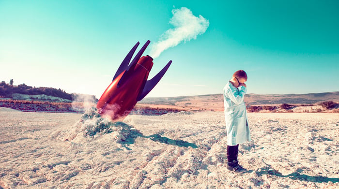 Boy in a lab coat is crying next to a crashed rocket.