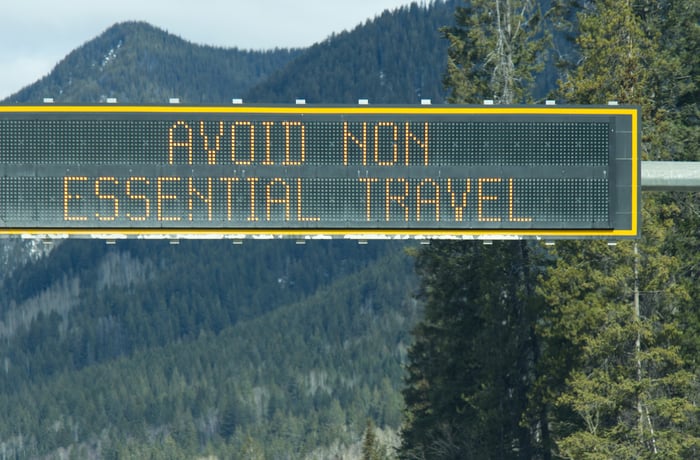 Road sign reads AVOID NON ESSENTIAL TRAVEL.