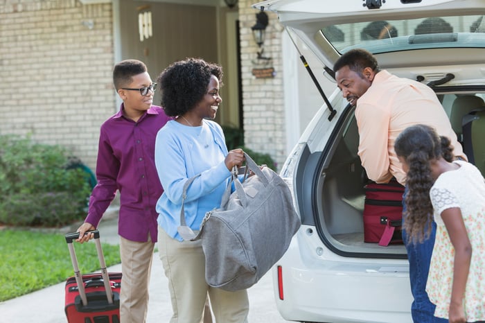A family loading luggage in their car.