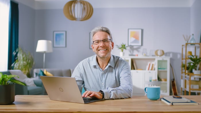 A person at a laptop smiling.