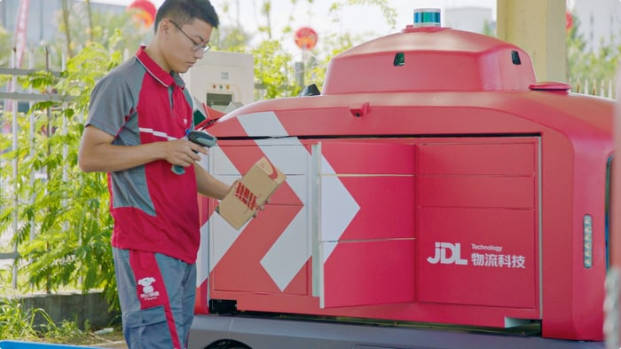 A JD.com worker with an autonomous vehicle.