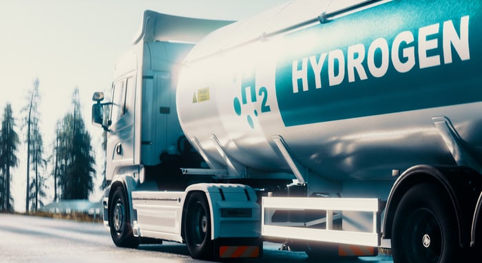 hydrogen fuel tanker truck with H2 and Hydrogen written on the side.